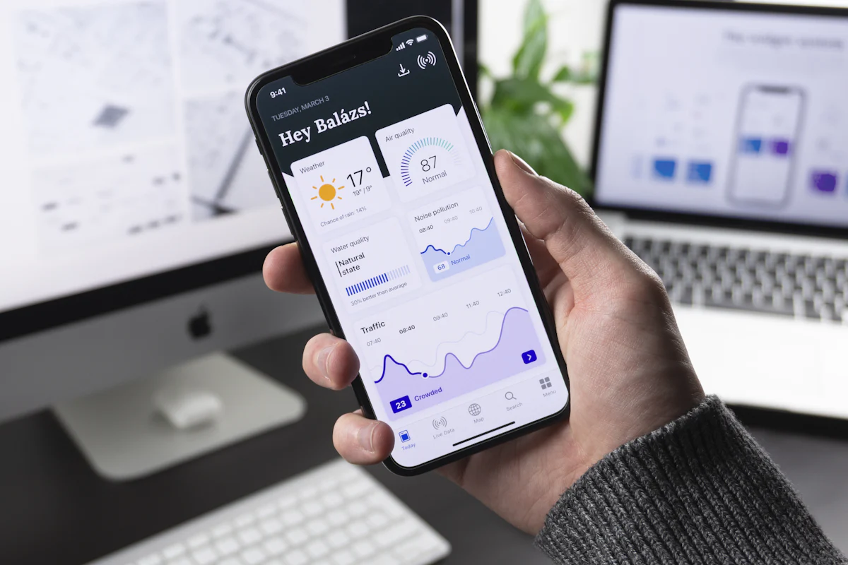 Hand holding a phone with a mobile app dashboard