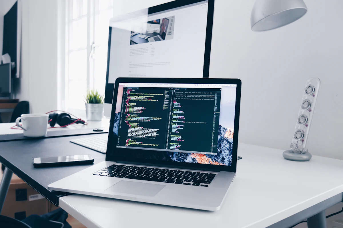 Laptop showing website code on a designer’s desk